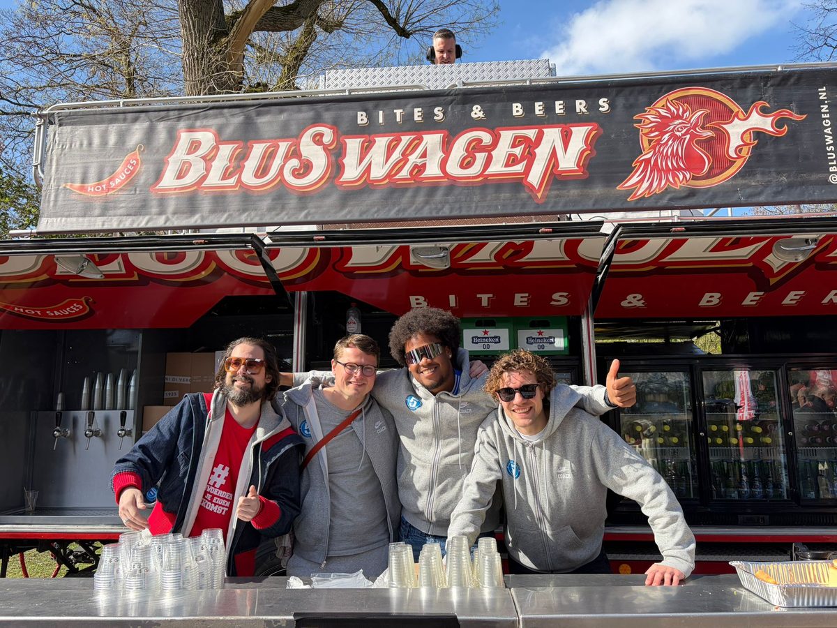Vier vrijwilligers achter de bar van de BluSwagen